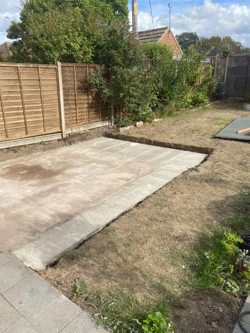 Completed concrete log cabin base extension in the Yateley garden